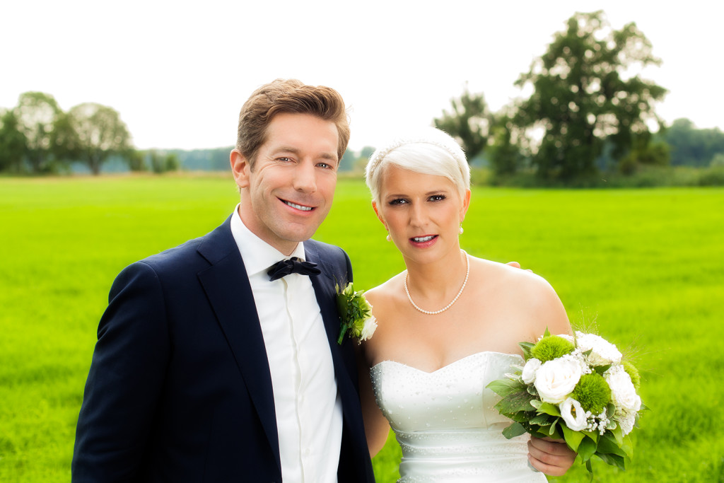 Hochzeitsfoto mit dem Brautpaar auf einer Wiese